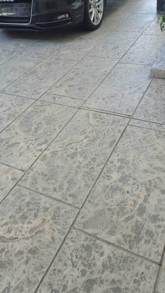 Picture of stamped concrete driveway in a modern large tile design stained in gray color tones overlay design.
