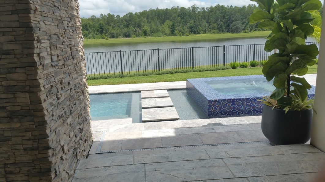 picture of stamped concrete pool deck overlooking pool and conservation area.